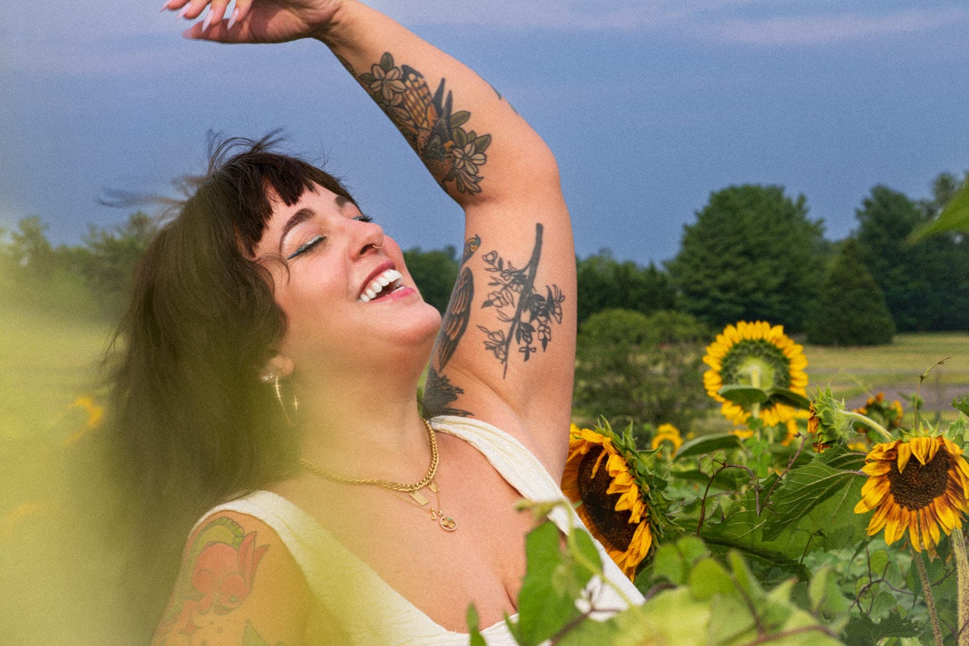 J.J. smiling, outdoors among the flowers.