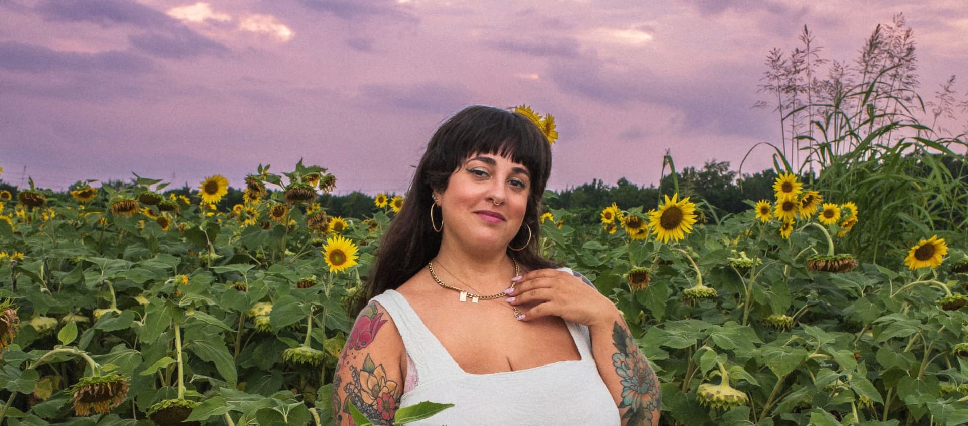 J.J. close up, outdoors in front of a wide flower field.